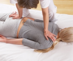 Rückansicht einer Frau, die eine Massage auf einer Liege erhält.